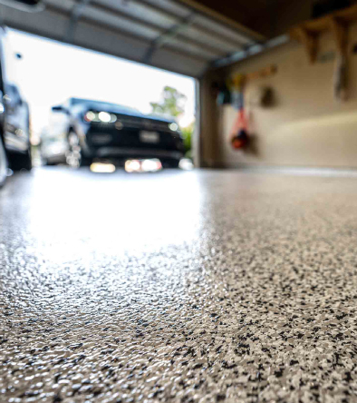 close up of sealed epoxy floor with a black car - Innovative Garage Flooring polyaspartic flooring