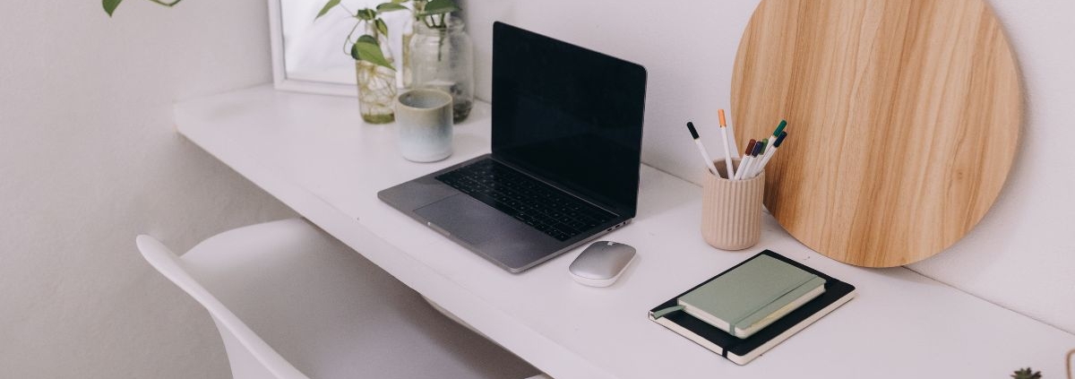 workspace with a white desk and silver laptop - Innovative Garage Flooring Commercial Flooring Solutions