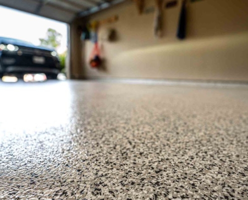 close up of flake flooring with a polyaspartic coating - Innovative Garage Flooring polyaspartic floor coating