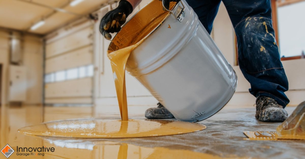 person pouring yellow liquid onto a floor - Innovative Garage Flooring polyaspartic floor coating